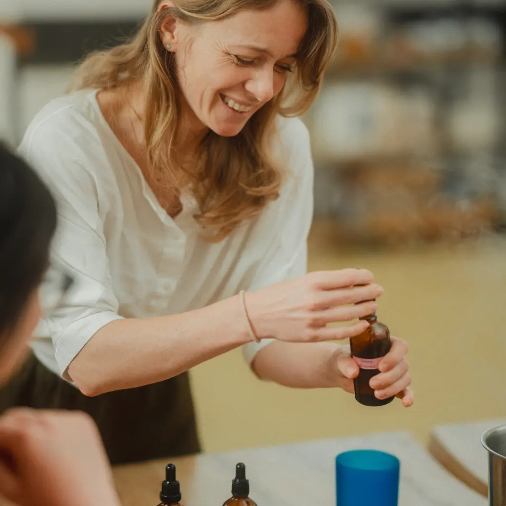 Pouring fragrance into a soy candle during a workshop in Prague